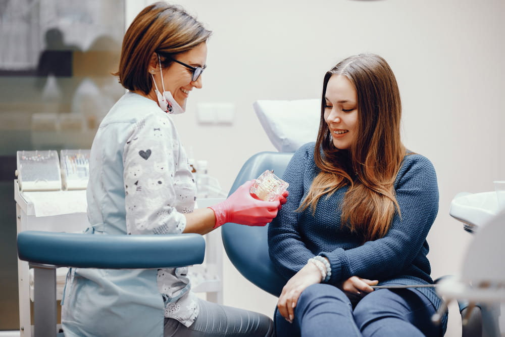 Dentista de Zaragoza haciendo una demostración de cmo lavar unos dientes con una mandibula de mentira