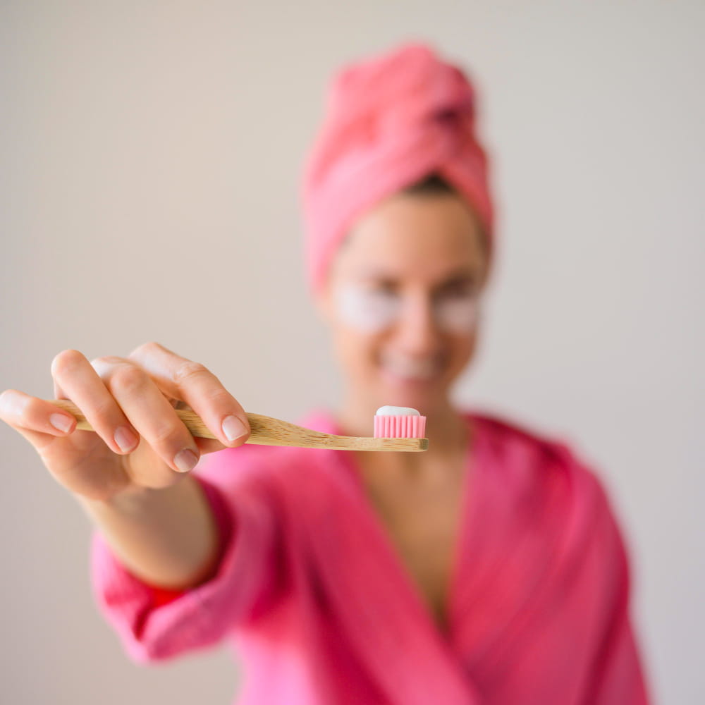Chica enseñando un cepillo de dientes para la limpieza de la boca